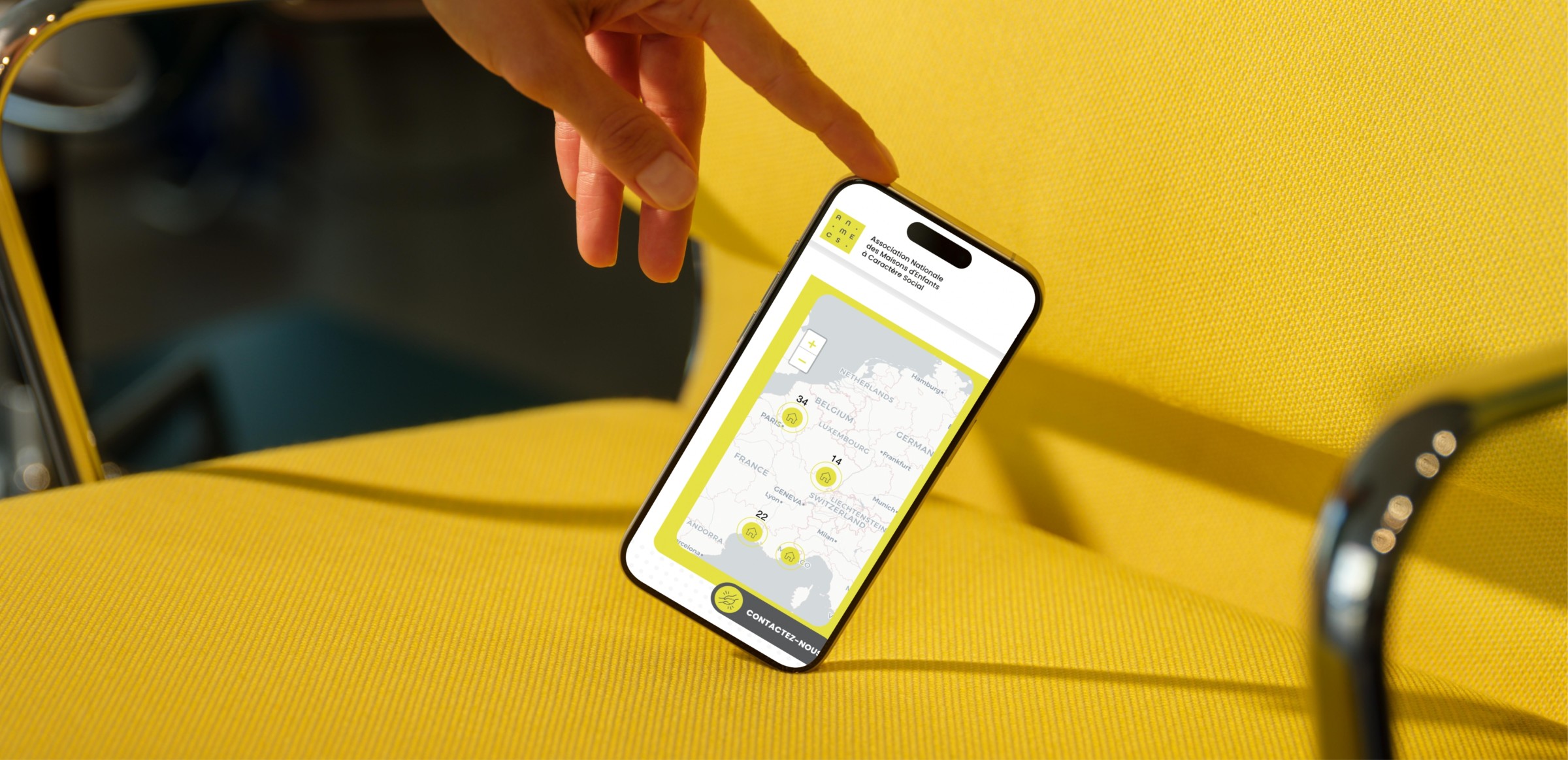 Mockuuups Iphone 15 Pro Mockup With Hand Interaction On Yellow Chair